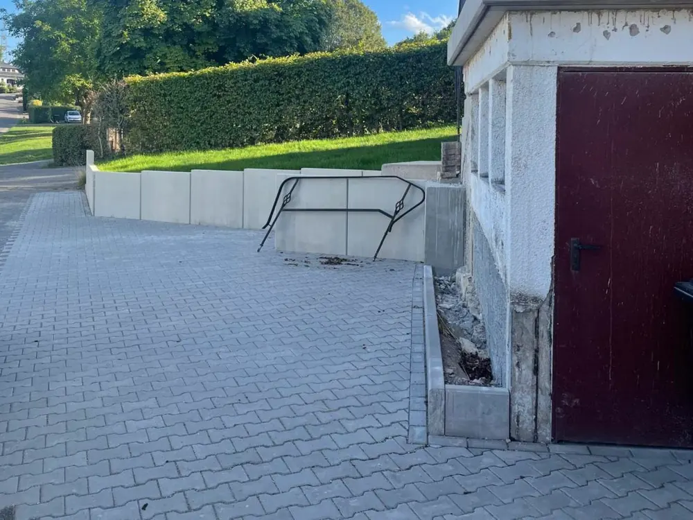Einfahrt nach dem Umbau mit neuer Winkelsteinmauer und Pflaster